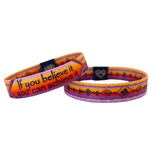 May include: Two colourful woven bracelets with a purple, orange and yellow pattern. One bracelet has the text "If you believe it you can achieve it" printed in black.