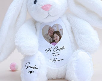 May include: White plush bunny with long ears, a heart-shaped window on its chest with a photo of two people, and the text "A Cuddle From Heaven" and "Grandpa" on the paws.