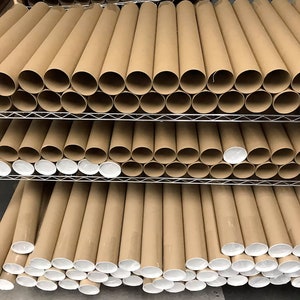 May include: A stack of brown cardboard mailing tubes with white end caps. The tubes are stacked on a metal shelf.