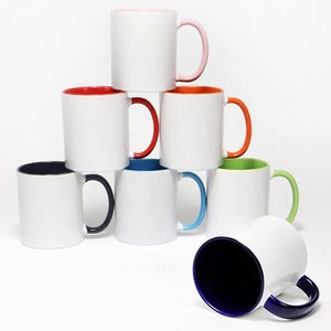 Puede incluir: Un conjunto de ocho tazas de cer&aacute;mica blanca con bordes y asas de colores. Las tazas est&aacute;n dispuestas en forma de pir&aacute;mide, con la taza superior con un borde y asa de color rosa, la segunda taza con un borde y asa de color naranja, la tercera taza con un borde y asa de color rojo, la cuarta taza con un borde y asa de color azul, la quinta taza con un borde y asa de color verde, la sexta taza con un borde y asa de color negro, y la s&eacute;ptima taza con un borde y asa de color azul. La octava taza est&aacute; tumbada de lado con un borde y asa de color azul.