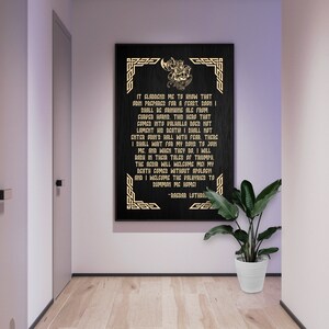 May include: A black framed print with gold lettering and a decorative border. The print features a quote from Ragnar Lothbrok, a famous Viking warrior, about his death and afterlife. The quote reads: "It gladdened me to know that Odin prepares for a feast. Boon I shall be drinking ale from curved horns. This hero that comes into Valhalla does not lament his death! I shall not enter Odin's hall with fear. There I shall wait for my sons to join me. And when they do, I will bask in their tales of triumph. The agdir will welcome me! My death comes without apology! And I welcome the Valkyries to summon me home!" -Ragnar Lothbrok