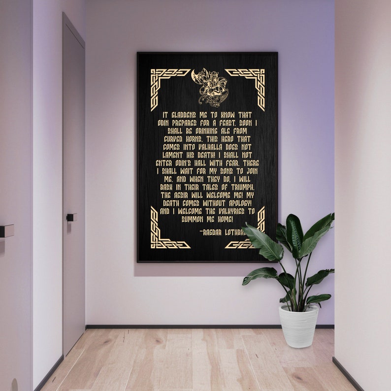 May include: A black framed print with gold lettering and a decorative border. The print features a quote from Ragnar Lothbrok, a famous Viking warrior, about his death and afterlife. The quote reads: "It gladdened me to know that Odin prepares for a feast. Boon I shall be drinking ale from curved horns. This hero that comes into Valhalla does not lament his death! I shall not enter Odin's hall with fear. There I shall wait for my sons to join me. And when they do, I will bask in their tales of triumph. The agdir will welcome me! My death comes without apology! And I welcome the Valkyries to summon me home!" -Ragnar Lothbrok