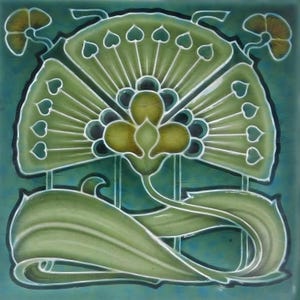 May include: A square ceramic tile featuring an Art Nouveau floral design. The tile has a teal background with a central flower in shades of green and yellow. The flower is surrounded by stylized leaves and heart-shaped accents, outlined in white.
