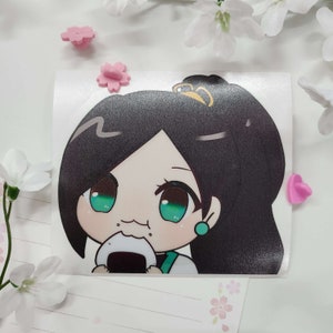 May include: A sticker featuring a cartoon illustration of a person with long black hair, green eyes, and a pink earring. The person is wearing a white shirt with a green collar and is eating a rice ball.