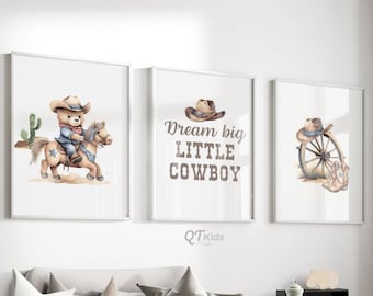 May include: Three framed prints with a cowboy theme. The first print shows a teddy bear wearing a cowboy hat riding a brown horse. The second print says "Dream big little cowboy". The third print shows a cowboy hat and a wagon wheel.