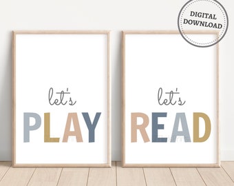 May include: Two framed prints with the text "let's play" and "let's read" in colourful letters. The prints are on a white background and have a light wood frame.