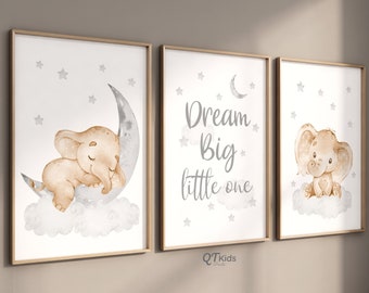Op de afbeelding: Set van drie kinderkamerprints met een aquarelillustratie van een bruine olifant die slaapt op een halve maan met sterren, een print met de tekst "Dream Big little one" met sterren en een halve maan, en een print met een bruine olifant die op een wolk zit met sterren.