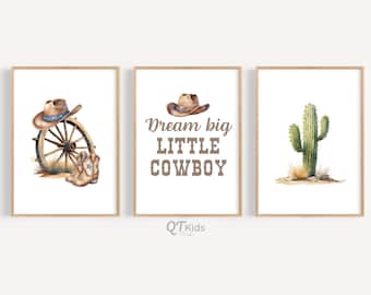 May include: Three watercolor prints with a western theme. The first print features a cowboy hat, boots, and a wagon wheel. The second print says "Dream big little cowboy". The third print features a green cactus.