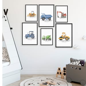 May include: Set of six watercolor illustrations of construction vehicles, including a bulldozer, dump truck, excavator, tractor, cement mixer, and a roller. The illustrations are framed in black frames and hung on a white wall.