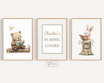 Puede incluir: Tres láminas enmarcadas para la guardería. La primera presenta un oso leyendo un libro, la segunda dice "Charlie's READING CORNER", y la tercera muestra un conejito leyendo. Todas están en marcos de madera con una paleta de colores suave y neutra.