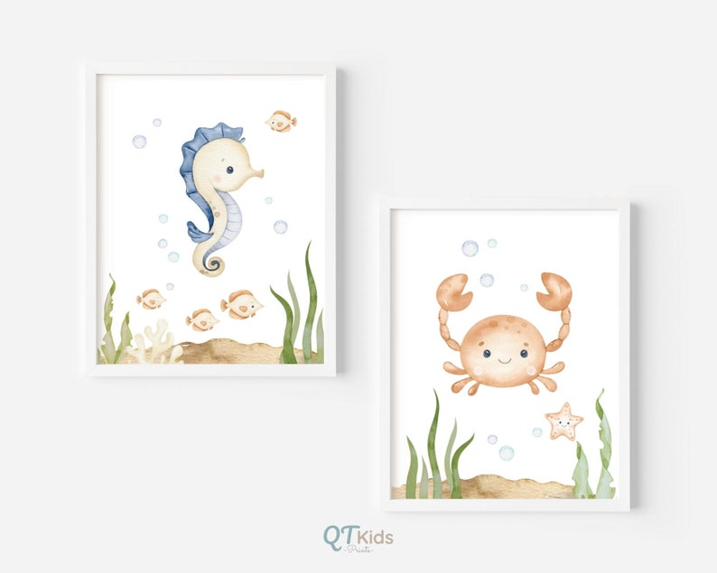 May include: Two watercolor illustrations of sea creatures in white frames. The first illustration features a blue and white seahorse with a light brown background and small orange fish. The second illustration features a brown crab with a light brown background and a yellow starfish.