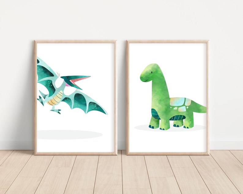 May include: Two framed prints featuring watercolor illustrations of dinosaurs. The print on the left shows a blue and green pterodactyl with its mouth open. The print on the right shows a green brachiosaurus with a light blue and green pattern on its back.
