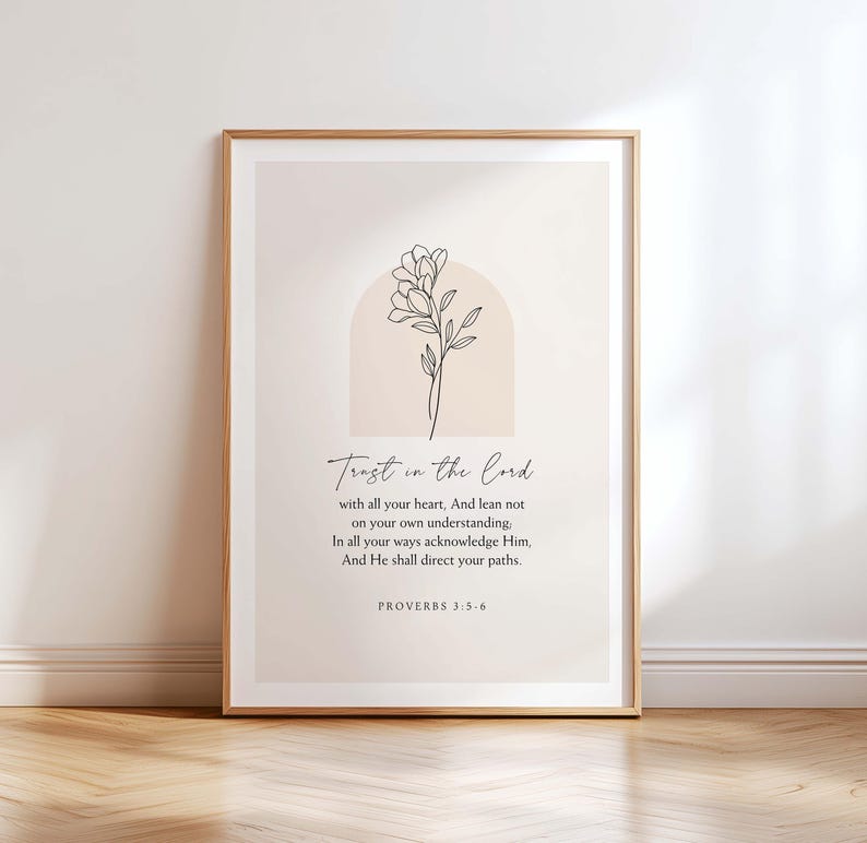 May include: Framed art print featuring the text "Trust in the Lord" with a floral line drawing. The artwork includes the scripture Proverbs 3:5-6. The print has a neutral color palette with a beige background and a light brown frame.