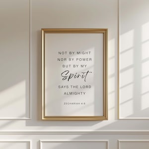 Könnte beinhalten: Ein gerahmter Druck mit einem goldfarbenen Rahmen. Der Druck zeigt die Worte "NOT BY MIGHT NOR BY POWER BUT BY MY Spirit SAYS THE LORD ALMIGHTY ZECHARIAH 4:6" in schwarzer Schrift auf weißem Hintergrund. Der Rahmen ist rechteckig.
