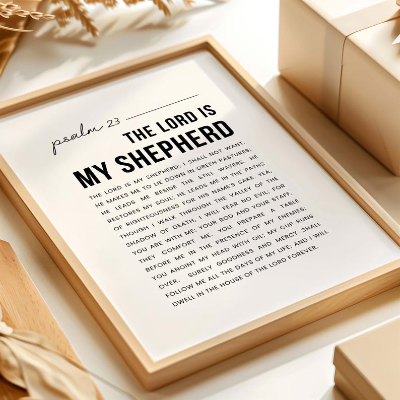 May include: A framed print with the text "THE LORD IS MY SHEPHERD" in a bold, black font. The text is a passage from Psalm 23, printed on a white background. The frame is a light wood color.