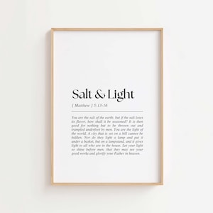 Könnte beinhalten: Gerahmter Druck mit dem Text "Salt & Light" in schwarzer Schrift. Darunter steht ein Bibelvers aus Matthäus 5:13-16. Der Text befindet sich auf weißem Hintergrund, umrahmt von einem hellbraunen Holzrahmen. Für die Inneneinrichtung.