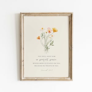 May include: Framed art print featuring a watercolor floral arrangement in shades of yellow, orange, and pink. The print includes the text "YOU WILL KEEP HIM in perfect peace." The frame is a light brown color.
