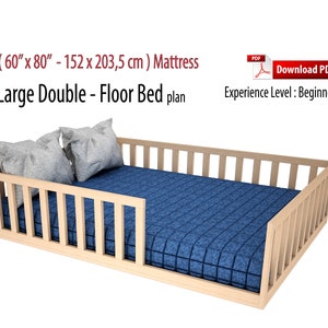Puede incluir: Planos de bricolaje para una cama doble de suelo grande para un colchón de 152 x 203,5 cm. El marco de la cama está hecho de madera y tiene una cabecera y un piecero de listones. La cama se muestra con un colchón azul y dos almohadas grises.