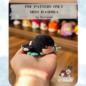 May include: A handmade crochet doll of a character with black hair and a tan face, held in a hand. The doll has a black head and a light green collar. The text "PDF PATTERN ONLY MIST HASHIRA by: Knotunzel" is visible in the image.