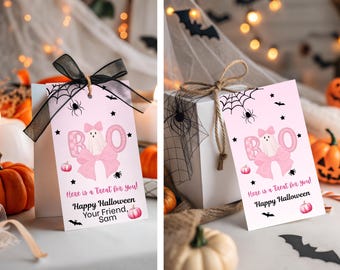 Może przedstawiać: Różowa etykieta prezentowa na Halloween z duchem, kokardą i napisem "BOO". Etykieta zawiera tekst "Here is a Treat for you! Happy Halloween Your Friend, Sam". Czarne wstążki i pajęczyny dopełniają projekt.