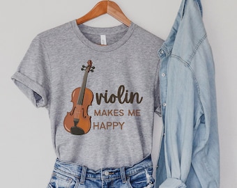 May include: A grey t-shirt with a brown violin illustration and the text "violin makes me happy".