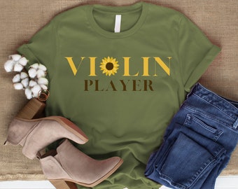 May include: A green t-shirt with the text "VIOLIN PLAYER" in yellow and brown letters. A sunflower graphic is between the words "VI" and "OLIN".