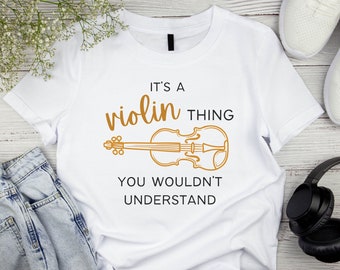May include: White t-shirt with the text "It's a violin thing you wouldn't understand" and a line drawing of a violin in gold.