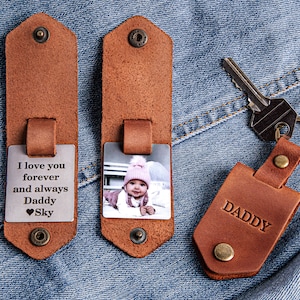 May include: A brown leather keychain with a photo insert and a metal tag that says "I love you forever and always Daddy Sky". The keychain also has a separate brown leather tag that says "Daddy".