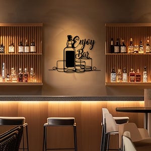 Peut inclure: Décoration murale en métal noir avec une bouteille et des verres, et le texte "Enjoy Bar".