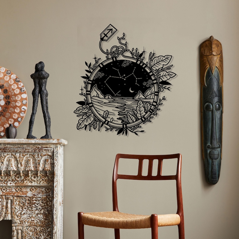 Puede incluir: Arte de pared en blanco y negro con una ilustraci&oacute;n estilizada de un reloj de bolsillo con una constelaci&oacute;n en su interior. El reloj est&aacute; rodeado de follaje y tiene una peque&ntilde;a flecha en la parte superior.