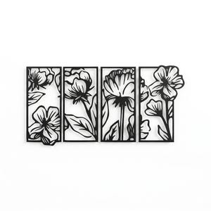 May include: Black metal floral wall art. The artwork features four rectangular panels with cut-out designs of various flowers and leaves. The flowers are in different stages of bloom, creating a dynamic and artistic display. The piece is designed to be mounted on a wall.
