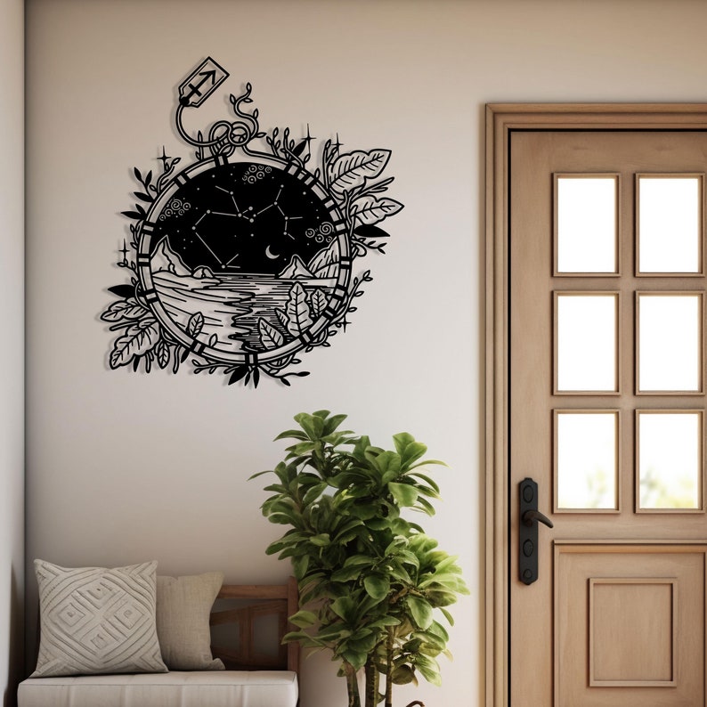Puede incluir: Arte de pared de metal negro con un dise&ntilde;o circular que representa una escena de cielo nocturno, una constelaci&oacute;n y una luna creciente. El dise&ntilde;o est&aacute; rodeado de hojas y enredaderas estilizadas.