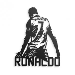 Op de afbeelding: Zwart metalen wandkunst silhouette van een voetballer met nummer 7 en de naam "RONALDO". De speler knielt met uitgestrekte armen. Decoratieve wanddecoratie.