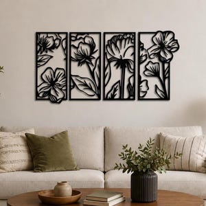 May include: Four-panel black metal floral wall art. Each panel features a different flower design with leaves, creating a cohesive botanical theme. The artwork is mounted on a neutral-colored wall above a sofa.