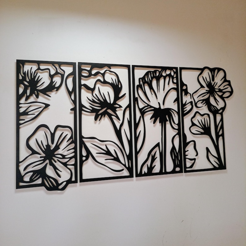 May include: A four-panel wall art piece featuring a floral design. Each panel is a black silhouette of flowers and leaves against a white background. The artwork is a modern, decorative accent for any room.