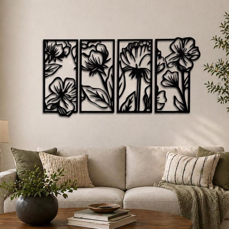 May include: Four-panel black metal wall art featuring floral designs. Each panel showcases a different flower, with intricate cut-out details. The artwork is mounted on a neutral-colored wall, creating a striking contrast. The overall theme is nature and home decor.