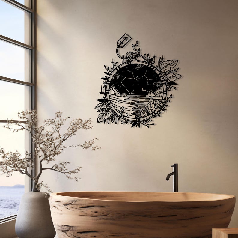 Puede incluir: Arte de pared de metal negro con un dise&ntilde;o circular que representa una escena de cielo nocturno, una luna creciente y una constelaci&oacute;n de estrellas. El dise&ntilde;o incluye una cordillera, una masa de agua y un borde floral. La constelaci&oacute;n est&aacute; etiquetada como "Sagitario".