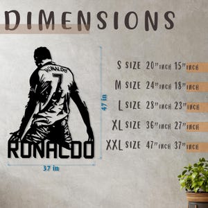 Op de afbeelding: Zwart metalen wandkunstsilhouet van een voetballer, met de naam "RONALDO" eronder. De afmetingen staan vermeld, de grootste maat is 119 cm bij 94 cm. De speler draagt een shirt met nummer 7.