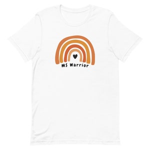 K&ouml;nnte beinhalten: Wei&szlig;es T-Shirt mit einem Regenbogen-Design in Orange- und Braunt&ouml;nen. Ein schwarzes Herz befindet sich in der Mitte des Regenbogens. Der Text "MS Warrior" befindet sich unter dem Regenbogen.