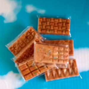 May include: Assortment of wax melts in various shapes and sizes, packaged in clear plastic. The wax melts are a light brown color with flecks of green and white.