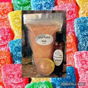 May include: A bath and body gift set with a sour patch kids theme. The set includes a 12 oz bag of bath salts, a bottle of moisturizing lotion, and a bath bomb. The bath salts are a light orange color, the lotion is in a clear bottle with a brown label, and the bath bomb is a light brown color.
