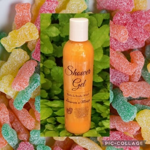 May include: Orange shower gel bottle with a white label that says "Shower Gel, Bath & Body Wash, Lauren's Wings". The bottle is surrounded by colorful gummy candies.