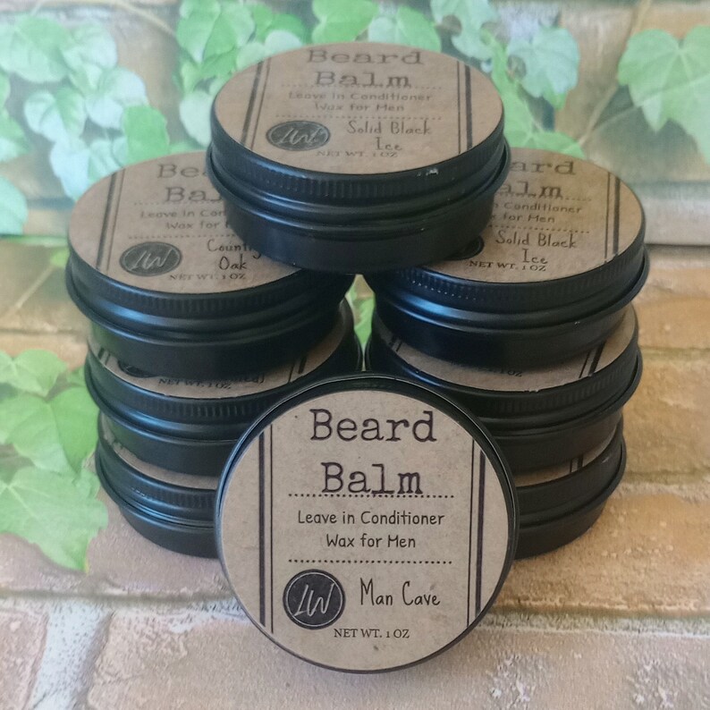 May include: A stack of eight small black tins with brown labels. The labels read "Beard Balm", "Leave in Conditioner Wax for Men", "Man Cave", "Net Wt. 1 oz", and "Solid Black Ice".