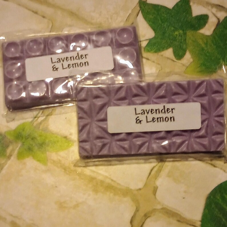 May include: Two purple wax melts, one with a textured surface and the other with a grid pattern. Both are labeled "Lavender & Lemon".