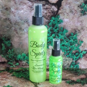 K&ouml;nnte beinhalten: Zwei gr&uuml;ne Glasflaschen mit schwarzen Spr&uuml;hk&ouml;pfen. Die gr&ouml;&szlig;ere Flasche hat ein Etikett mit der Aufschrift "Body Spritz Body Fragrance Spray Lauren's Wings". Die kleinere Flasche hat ein Etikett mit der Aufschrift "Body Spritz Body Fragrance Spray Lauren's Wings".