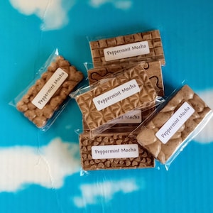 May include: Five individually wrapped bars of Peppermint Mocha flavored chocolate. Each bar has a different design and is wrapped in clear plastic.
