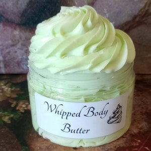 K&ouml;nnte beinhalten: Ein klares Glas mit hellgr&uuml;nem, geschlagenem K&ouml;rperbutter mit einem wei&szlig;en Etikett, auf dem "Whipped Body Butter" steht.