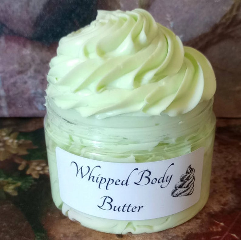K&ouml;nnte beinhalten: Ein klares Glas mit hellgr&uuml;nem, geschlagenem K&ouml;rperbutter mit einem wei&szlig;en Etikett, auf dem "Whipped Body Butter" steht.