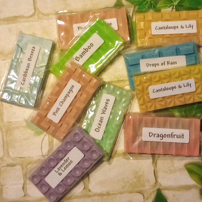 May include: Assortment of wax melts in various colors and scents, including Caribbean Breeze, Pink Champagne, Bamboo, Ocean Waves, Lavender & Lemon, Drops of Rain, Cantaloupe & Lily, and Dragonfruit.