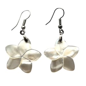 May include: A pair of drop earrings featuring white, iridescent, five-petaled flower charms made of shell. Each flower is suspended from a silver-toned metal hook wire, creating a dangling design that catches the light with a pearlescent finish.